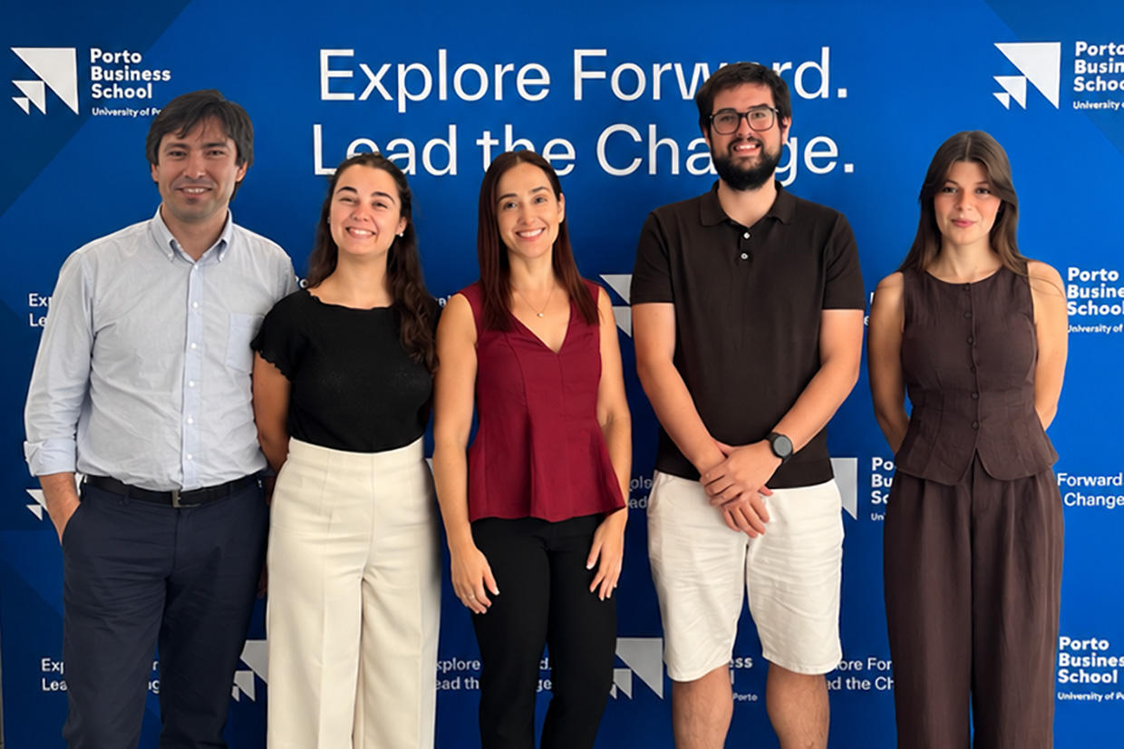 Equipa do projeto BERMICIN Care, de pé, em frente a um painel da Porto Business School